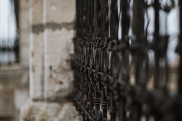 Black metal spiked residential fence diminishing to soft focus in the distance. background