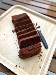Homemade Dark Bitter Chocolate Moist Sponge Cake Slices Slices in Tray with Knife.