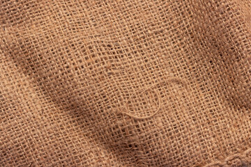 The texture of an uneven crumpled, roughly woven burlap.
