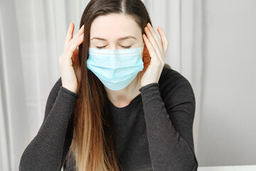 Young woman in mask has severe headache.
Headache with breathing mask. Pain from the mask