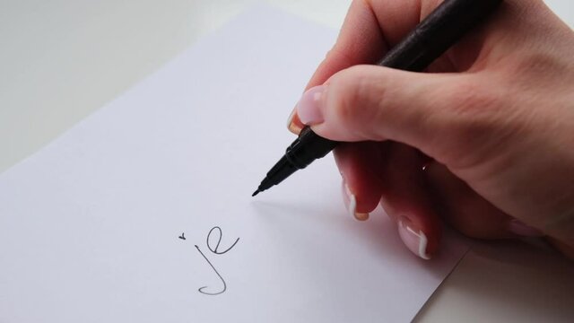 I love you inscription in french in black ink on white paper, love letter. Valentine's day concept.