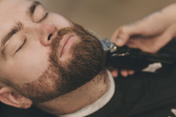 barber performs a beard haircut
