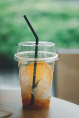 Ice cube and slice orange in the glass with black straws after drink.