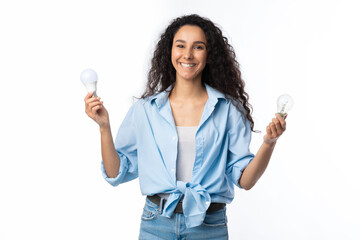 Fototapeta na wymiar Cheerful Lady Holding Two Lightbulbs Standing Over White Studio Background