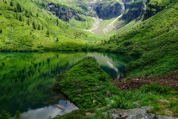 Naklejka na ściany i meble mountain lake between green mountain while hiking