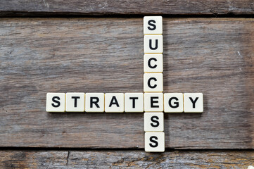 Top view of scrabble letters with text SUCCESS and STRATEGY over wooden background. Business and...
