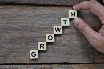 Hand putting alphabet letters with GROWTH wording. Business concept.