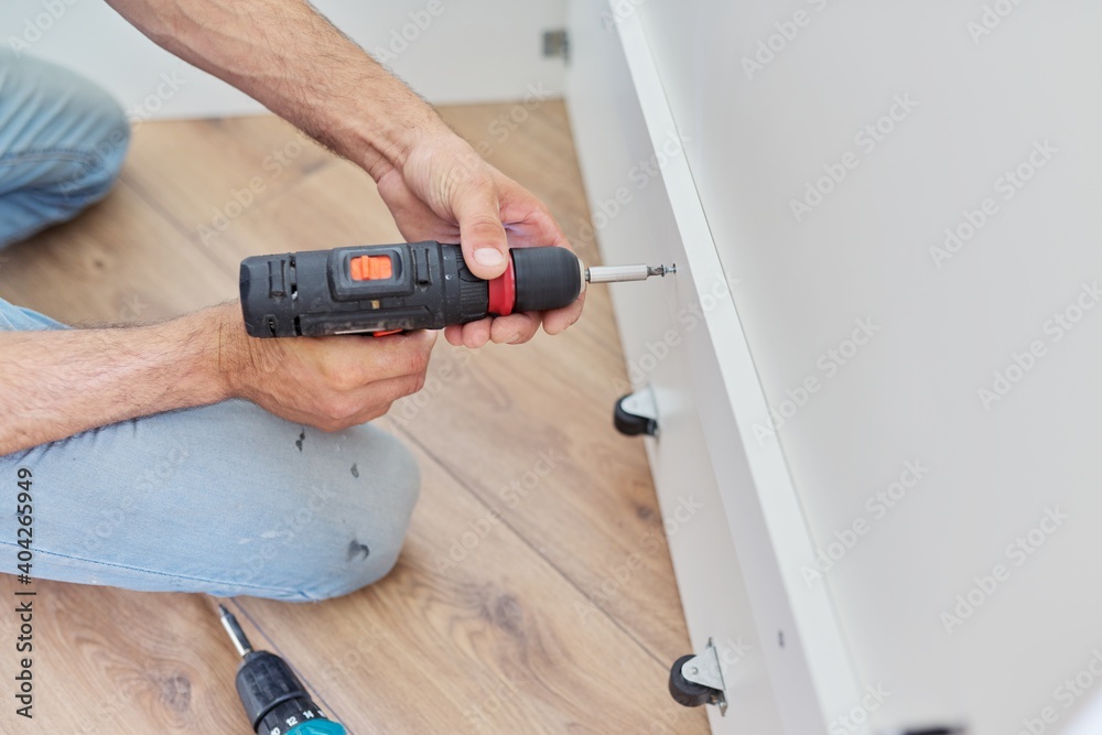 Wall mural close up detail of furniture and hands of carpenter worker with professional tool