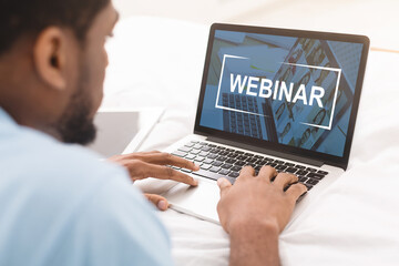 Black man having webinar on laptop while working in office