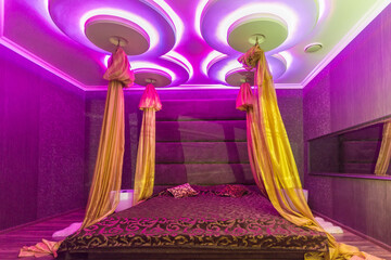 Romantic lounge, violet light color. Oriental style and a baldachin. © alhim