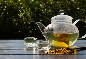 picture of people pouring hot water into clear glass kettle to make Chrysanthemum tea in afternoon...