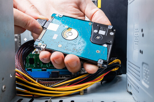 hard disk drive or hdd close up view. technician installing hdd to a desktop pc. inside view. pc repair service concept