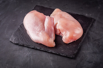 raw chicken fillet on a dark stone background