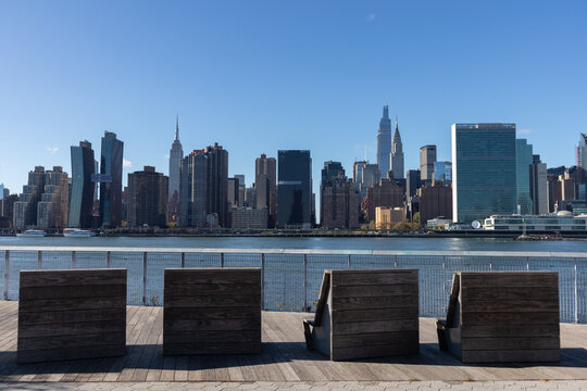 Empty Lounge Chairs along the Riverfront of Long Island City Queens New York with the Midtown Manhattan Skyline