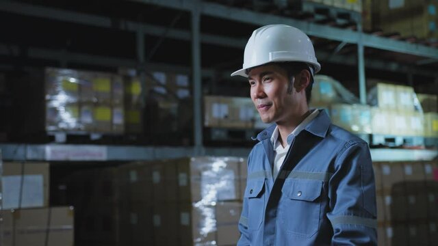 portrait of asian male professional enginner wearing uniform hardhat standing and smile with confident and cheerful in warehouse factory