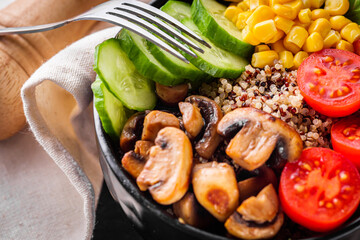 bowl of healthy quinoa with vegetables on a dark rustic background