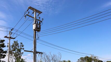 Transformer with a transmission line on a pole. Three-phase transformer with high and low voltage...