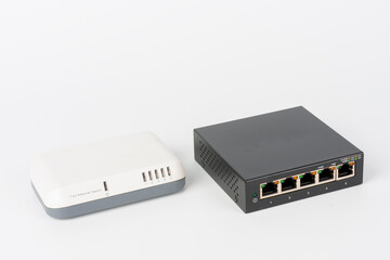 White slower 5-port 10 or 100 Mbps Fast Ethernet switch and black 5-port gigabit desktop switch.