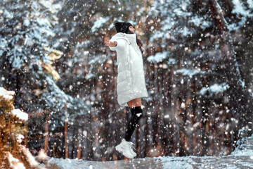 beautiful young girl in the winter forest, snow is falling. Concept for Christmas holidays, new year, winter, vacations.