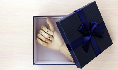 Wooden hand as a gift. Wooden hand in a blue gift box