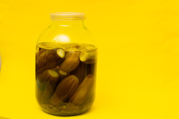 A jar of pickles, on a yellow background