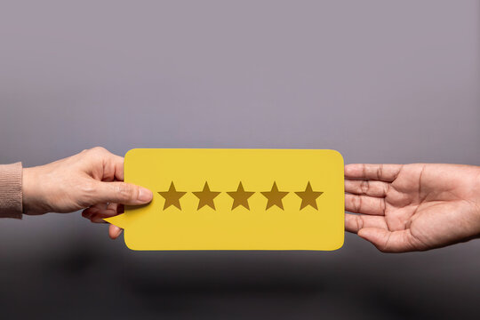 Customer Experience Concept, Happy Client giving a Feedback Card with Five Star Rating to a Businessman. Top View