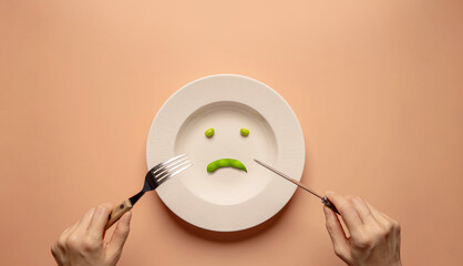 Diet and Health Care Concept. Try to Lose Weight. Young Woman Using Fork and Knife to Eating Green...