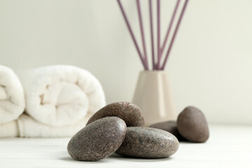 Pile of spa stones on white wooden table, closeup