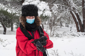 Young woman putting on her gloves before starting to ski.