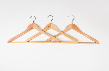Clothes hangers made of wood on a light background. Hangers made of environmentally friendly material