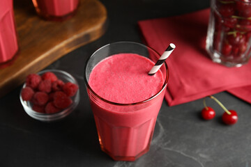 Tasty fresh milk shake with straw on black table, closeup