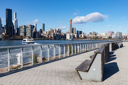 Row of Empty Park Benches along the Riverfront of Long Island City Queens New York with the Midtown Manhattan Skyline