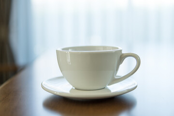 Close up of hot coffee cup on wooden table.