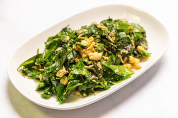 Stir-fried Malindjo leaves with egg; (Bai Lieng Pad Kai) a famous local food in Southern of Thailand.