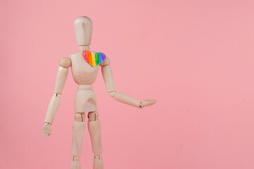 The wooden man with the LGBT heart on a pink background. Valentine's Day Card