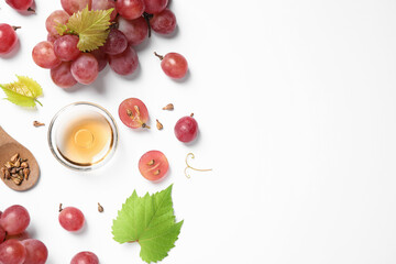Composition with bowl of natural grape seed oil on white background, top view. Organic cosmetic