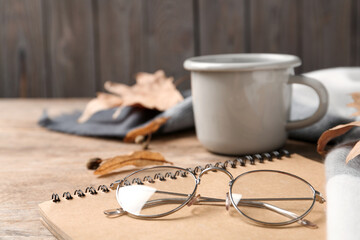 Notebook and glasses on wooden table, closeup. Space for text