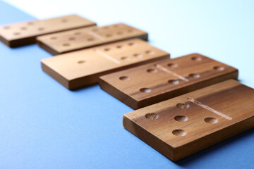Wooden domino tiles on color background, closeup