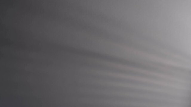 Blurry dark shadows moving on the wall. Spooky shadow art noise texture. closeup the motion of shadow batten of lath light on white wall texture background