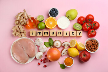 Set of natural products and cubes with word Immunity on pink background, flat lay