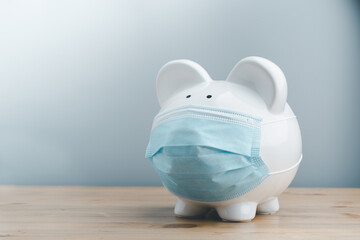 Piggy bank wearing surgical face mask. Global economy during coronavirus pandemic.  Financial crisis, banking concept. saving and investment.