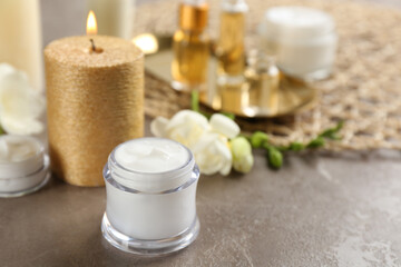 Fototapeta na wymiar Beautiful spa composition with cosmetic products and candle on table. Space for text