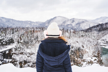 Fototapeta na wymiar Young woman traveler looking at beautiful landscape in winter