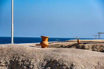 view of a deserted beach on a sunny day with sea and blue sky