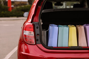 Shopping bags in car trunk outdoors, closeup