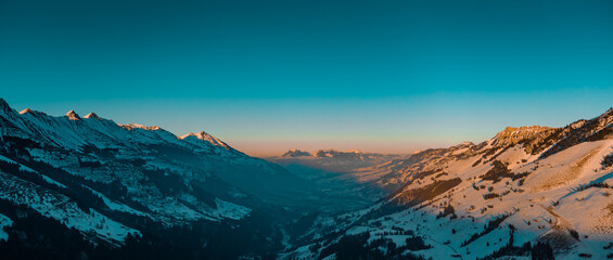 Wide aerial drone panorama above the Adelboden and Engstligen valley, in early evening with visible...