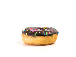 Chocolate flavoured donut with sprinkles on white background. One black doughnut isolated picture. Homemade bakery concept.