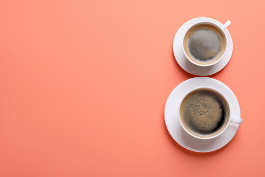 8 March greeting card design with cups of coffee and  space for text on coral background, flat lay. International Women's day