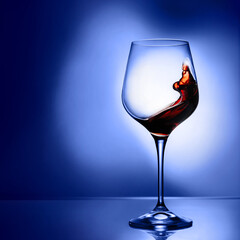 Glass with red wine on a blue background.