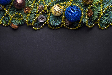 Fototapeta premium Black New Year background. Fir branches with New Year's toys and cones.